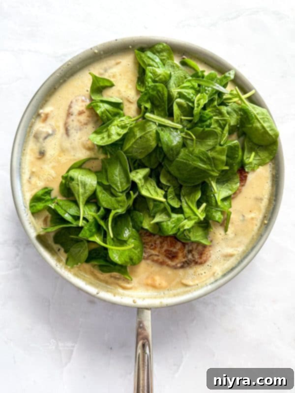 Chicken simmering in Florentine sauce
