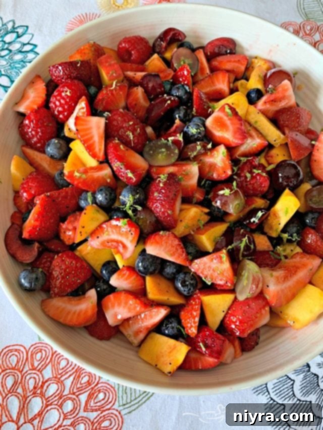 Vibrant Summer Fruit Salad with Honey Lime Poppy Seed Dressing, garnished with citrus zest.