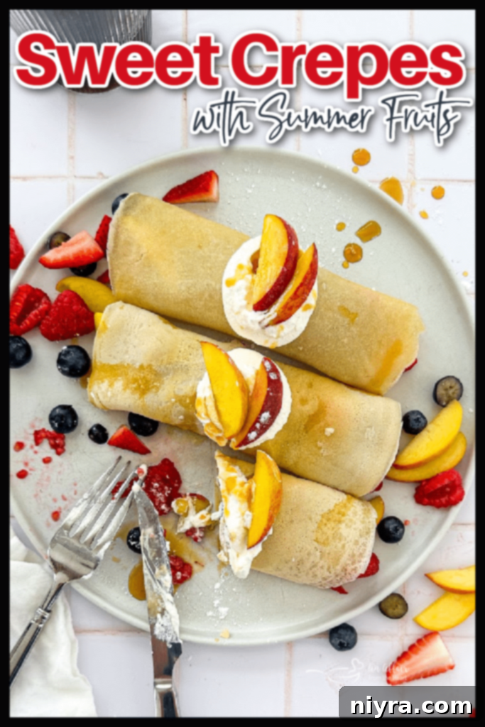 A stack of perfectly cooked golden crepes on a wire rack, with a small bowl of fresh berries nearby.