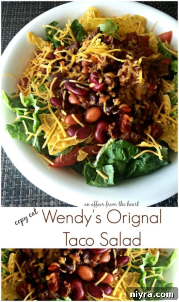 A beautifully assembled Copycat Wendy's Original Taco Salad, featuring warm chili, crisp lettuce, and fresh toppings, ready to be enjoyed