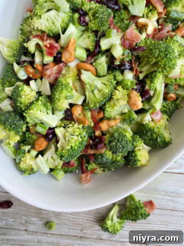 Top view of white bowl filled with bacon cashew broccoli salad
