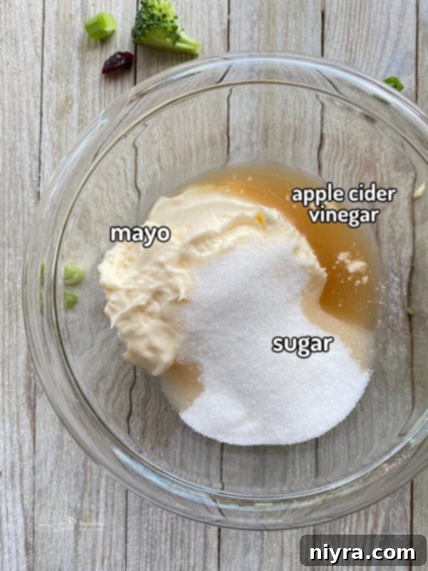 Top view of mayonnaise, sugar, and apple cider vinegar in bowl
