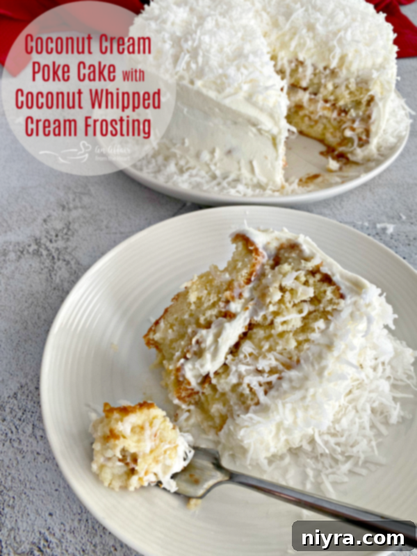 A stunning Coconut Cream Poke Cake with a luscious whipped cream frosting and shredded coconut on top, beautifully presented.
