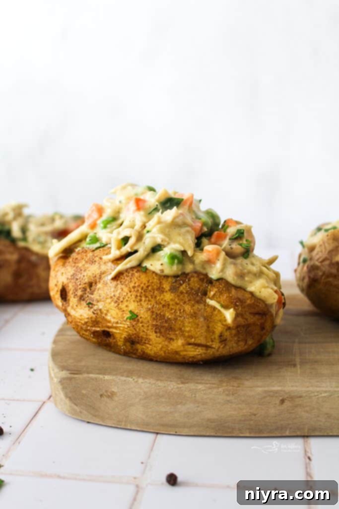 Close-up of a Chicken à la King Baked Potato, showcasing the creamy filling and fluffy potato interior.