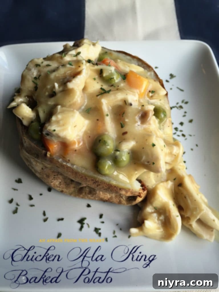 Chicken Ala King Baked Potato with fresh parsley garnish.