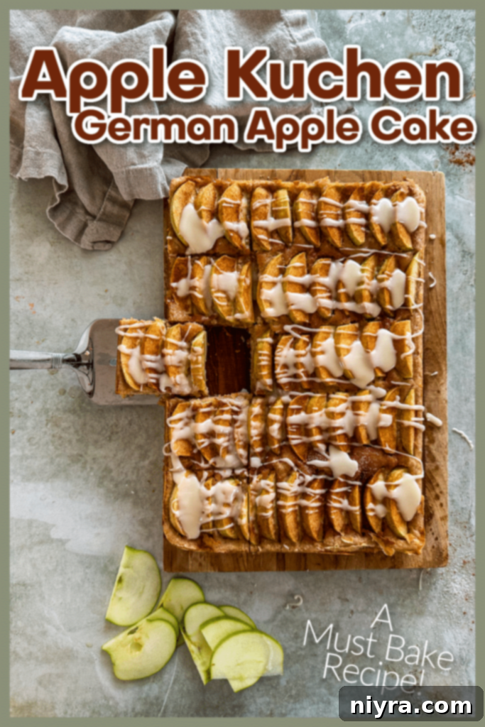 A generous serving of Apple Kuchen on a plate, garnished with a sprig of mint