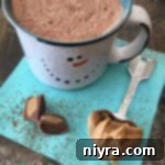 Hot cocoa, a spoon with peanut butter with text "Peanut Butter Hot Cocoa"