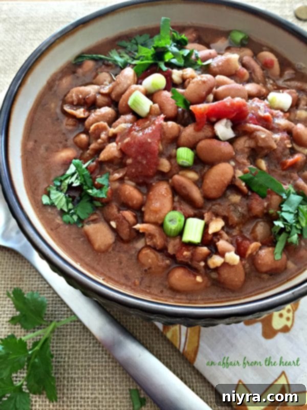 A close-up view of dried pinto beans soaking in water overnight, an essential first step for tender soup beans.