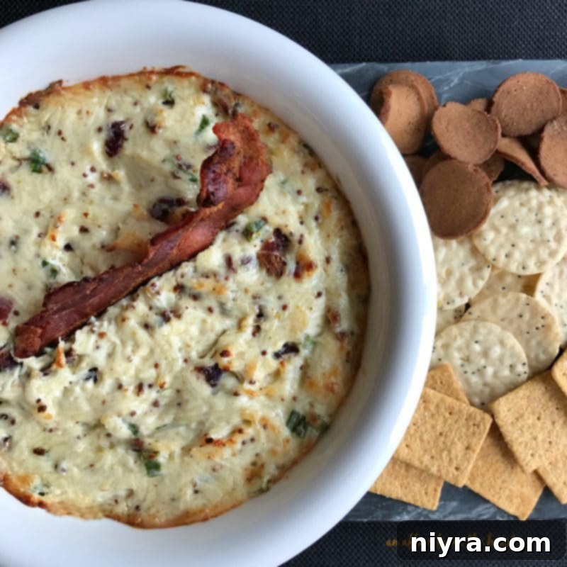 Hot Bacon and Swiss Dip 2 Delicious Hot Bacon & Swiss Dip served in a white bowl with crackers