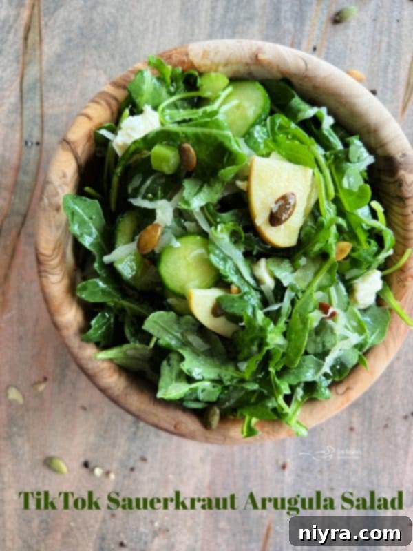 Hero shot of the vibrant TikTok Sauerkraut Arugula Salad in a large bowl on a picnic blanket.