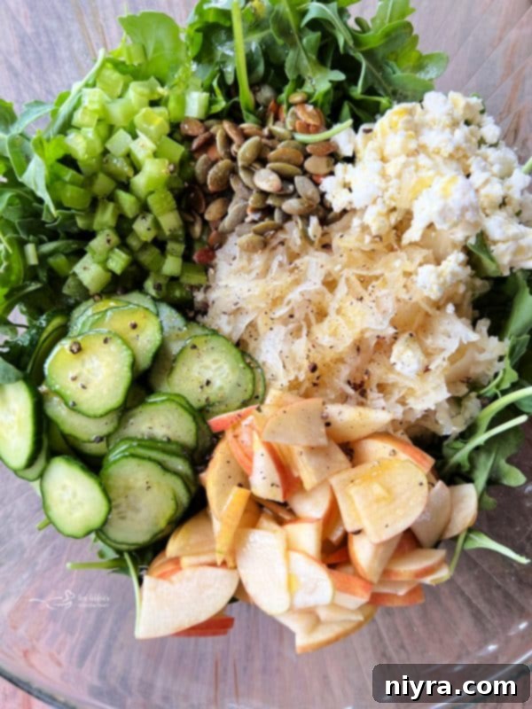 Tossing the Sauerkraut Arugula Salad with olive oil and pepper.