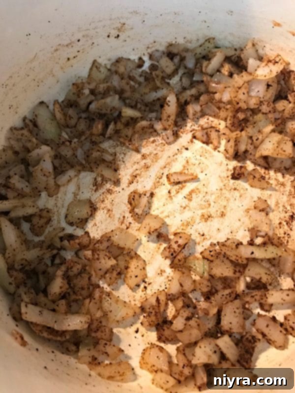 Chopped onion and aromatic spices ready to be sautéed in a pan for refried beans