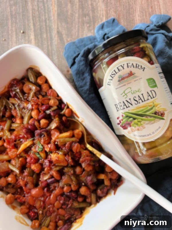A close-up shot of the Five Bean Baked Beans in a rustic serving dish, highlighting the texture and rich color.