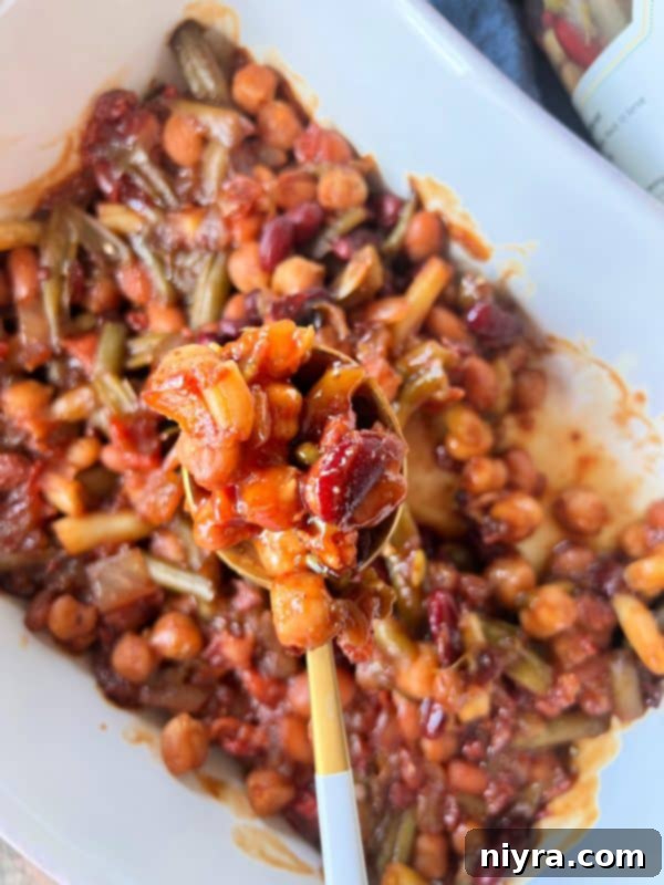 A close-up of a serving of Five Bean Baked Beans, emphasizing its rich texture and color, ready to be enjoyed.