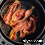 Freshly cooked air fryer bacon in the air fryer basket