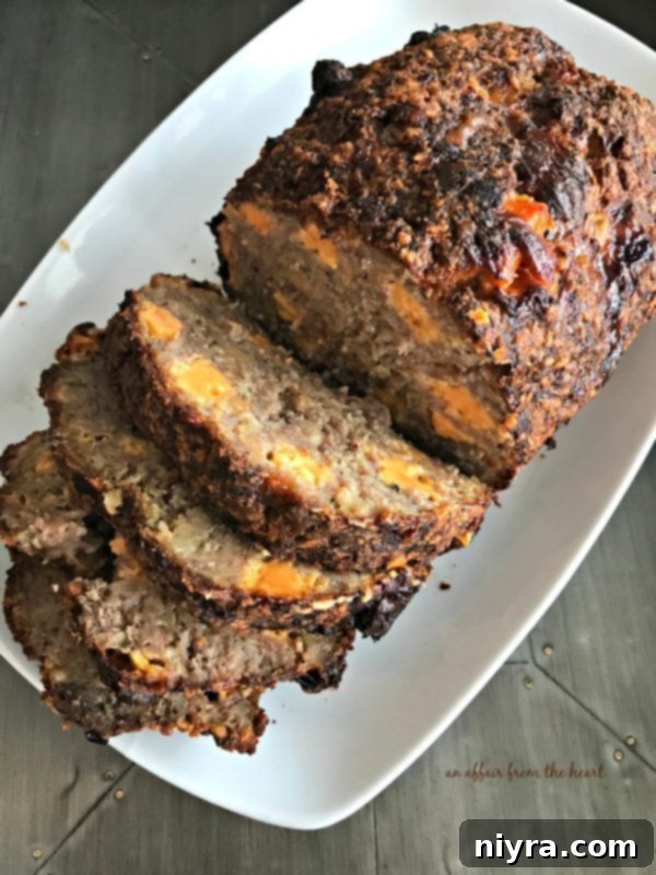 Full Pork Sausage Meatloaf, ready to be sliced, on a wooden board
