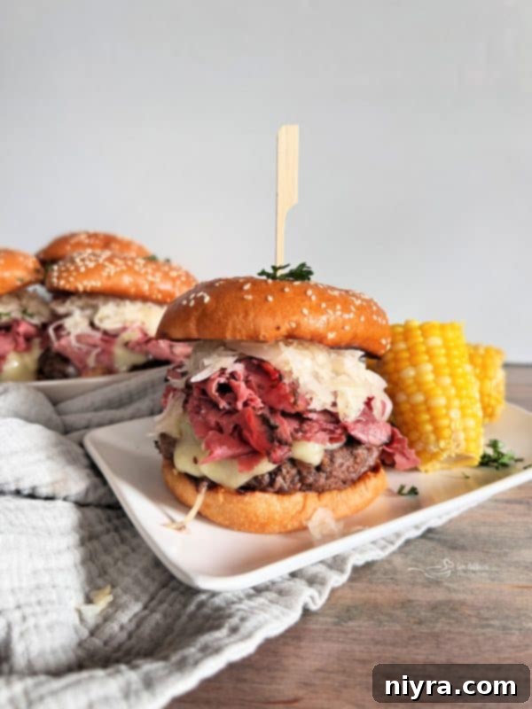 Pastrami Burger with Kraut served on a plate with corn on the cob