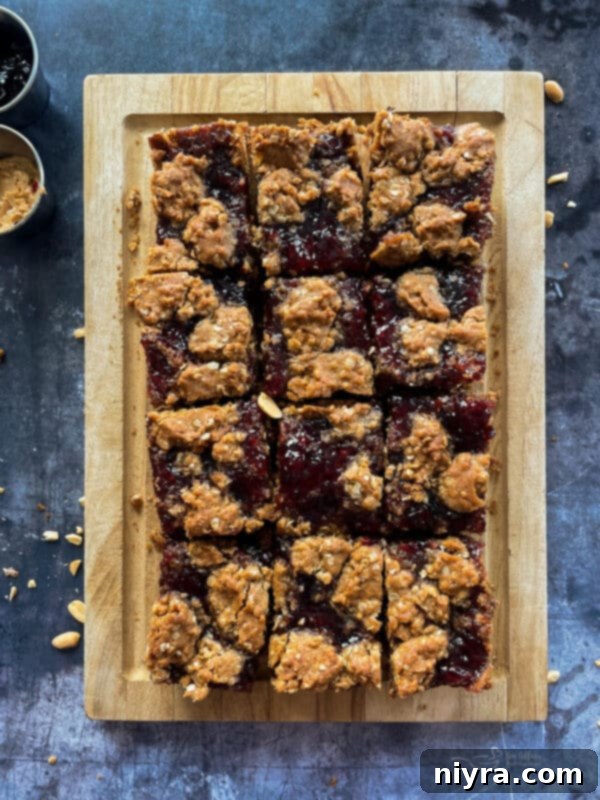 Close-up of Peanut Butter and Jelly Oatmeal Cookie Bars cut into squares, showcasing the swirled jelly