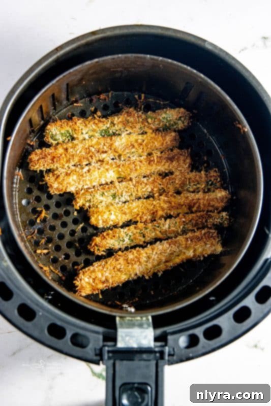 Crispy Air Fryer Zucchini 13 Zucchini fries arranged in a single layer in an air fryer basket