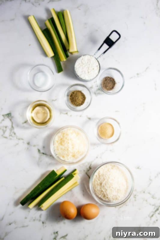 Crispy Air Fryer Zucchini 6 Close-up of ingredients for air fryer zucchini fries, including zucchini, eggs, flour, and spices