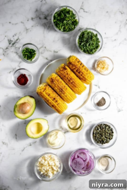 Selection of fresh ingredients for Grilled Corn and Avocado Salad laid out on a wooden cutting board