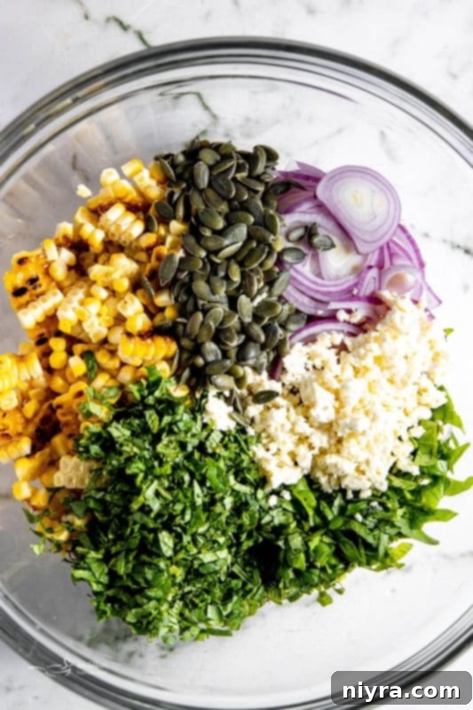 Step 3: Adding thinly sliced red onion and perfectly cubed ripe avocado to the bowl with the grilled corn