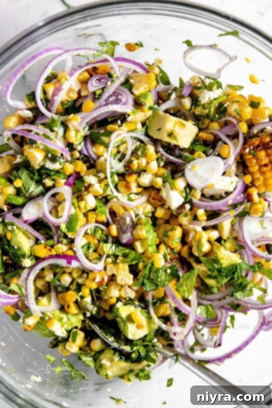 Step 3: Pepitas (pumpkin seeds) and crumbled feta cheese being sprinkled over the salad ingredients