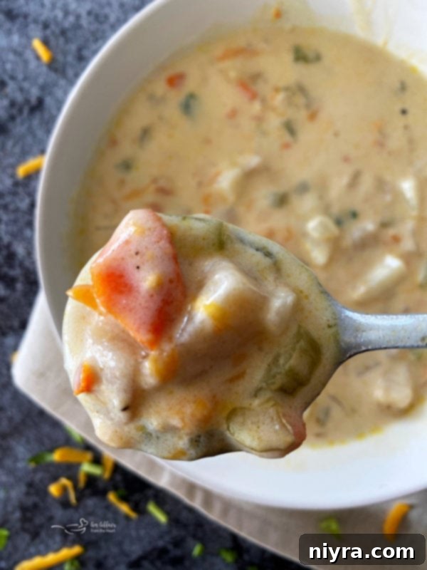 Close-up of a bowl of rich, cheesy potato soup, perfectly garnished and ready to be enjoyed.