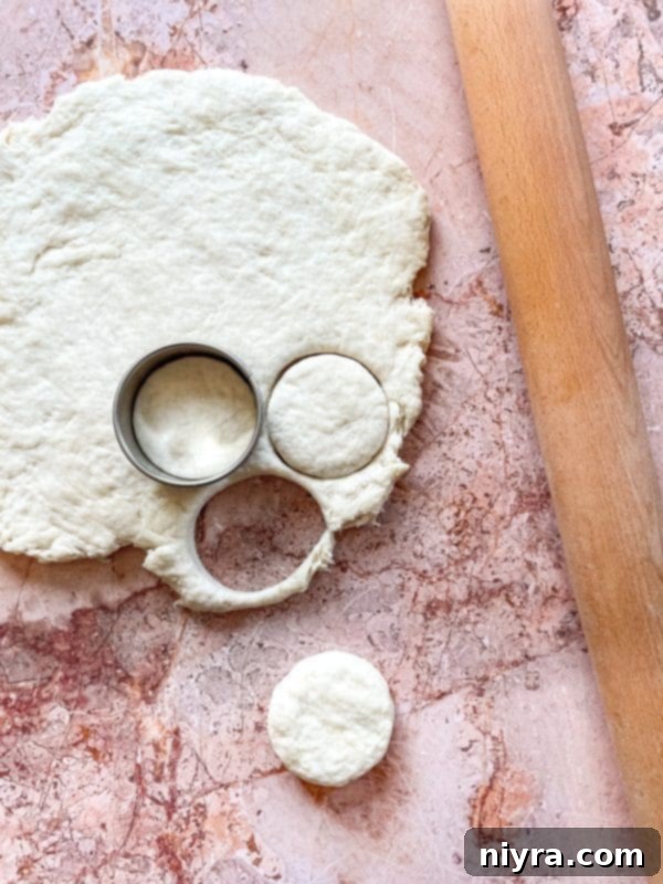 Fluffy Buttermilk Biscuits 10 Rolling biscuit dough on a floured surface