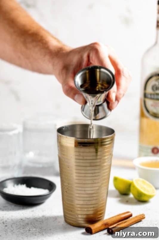 Apple Cider Margarita 8 A cocktail shaker filled with ice.