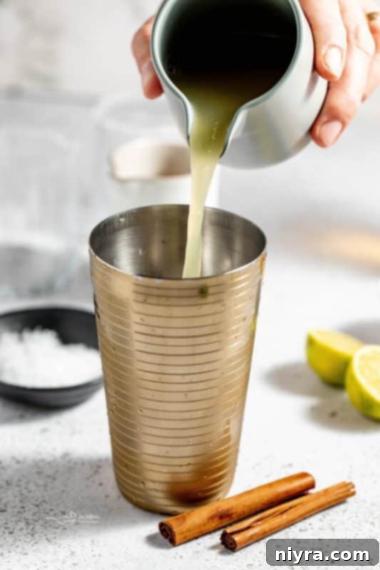 Apple Cider Margarita 9 Tequila and Grand Marnier being poured into a cocktail shaker.