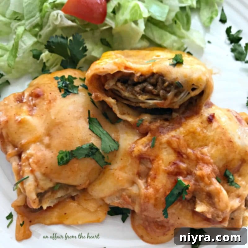 Slow Cooker Smothered Burritos served on a plate with sour cream and cilantro.