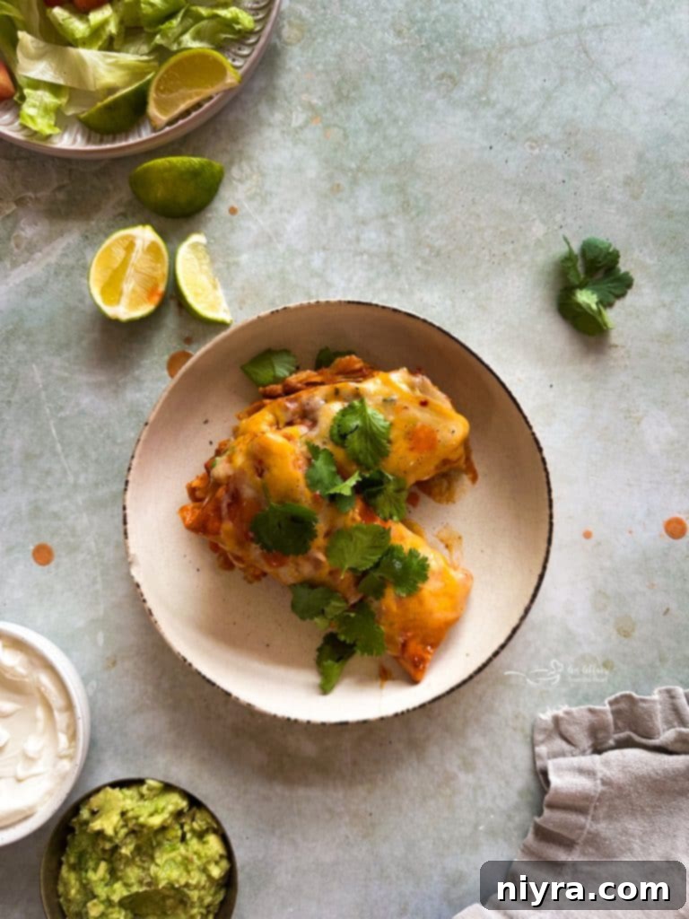 Melted cheese bubbling on top of slow cooker smothered burritos.