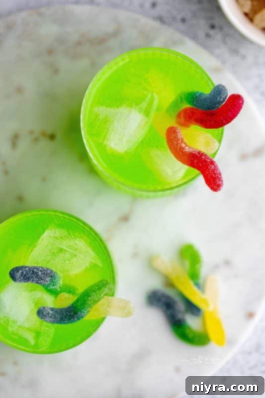 Close-up of Halloween Kids Punch in a glass with a creepy plastic spider and gummy worms.
