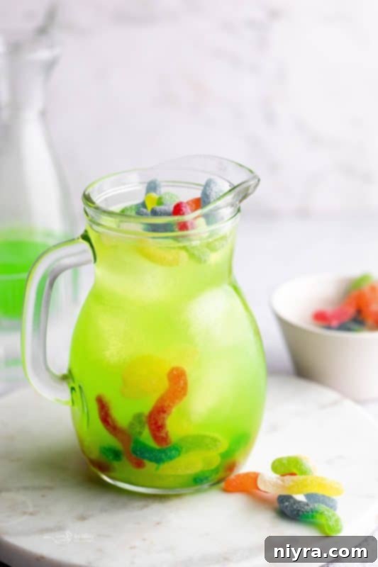 Halloween Kids Punch in a clear pitcher with ice and green Gatorade. The words 'Kids Halloween Punch' are overlayed.