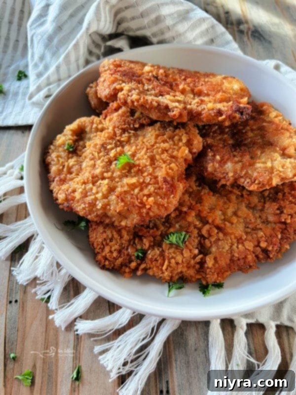 Crispy Pork Tenderloin Sandwich 17 Breaded pork cutlets in a white serving dish