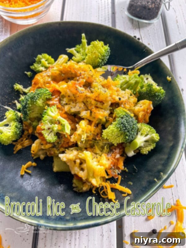 Front view of broccoli and cheese casserole on dark plate with spoon