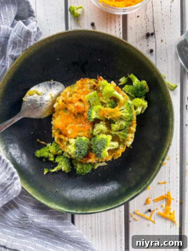 One serving of broccoli and cheese casserole on dark plate