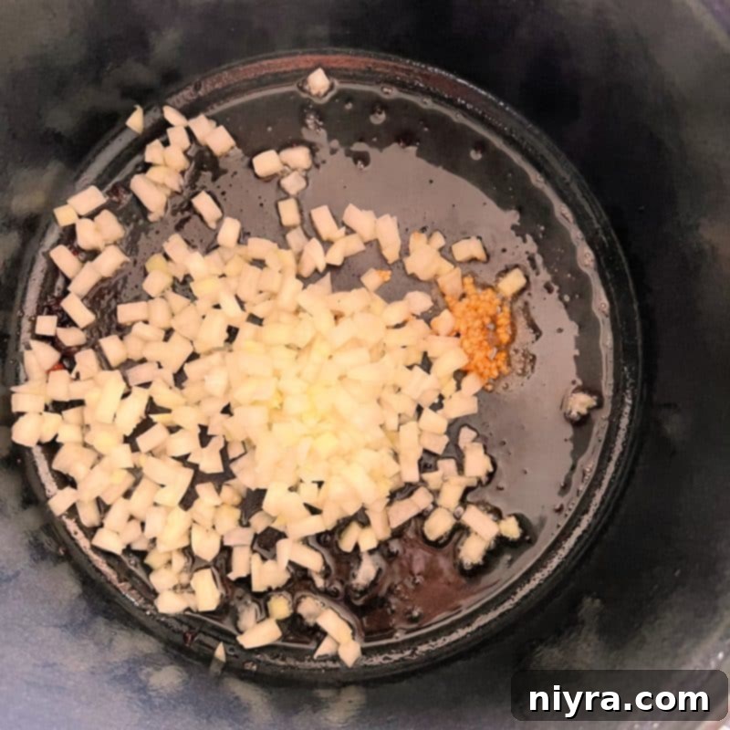 Step 2: Sautéing onions and garlic in sausage drippings.