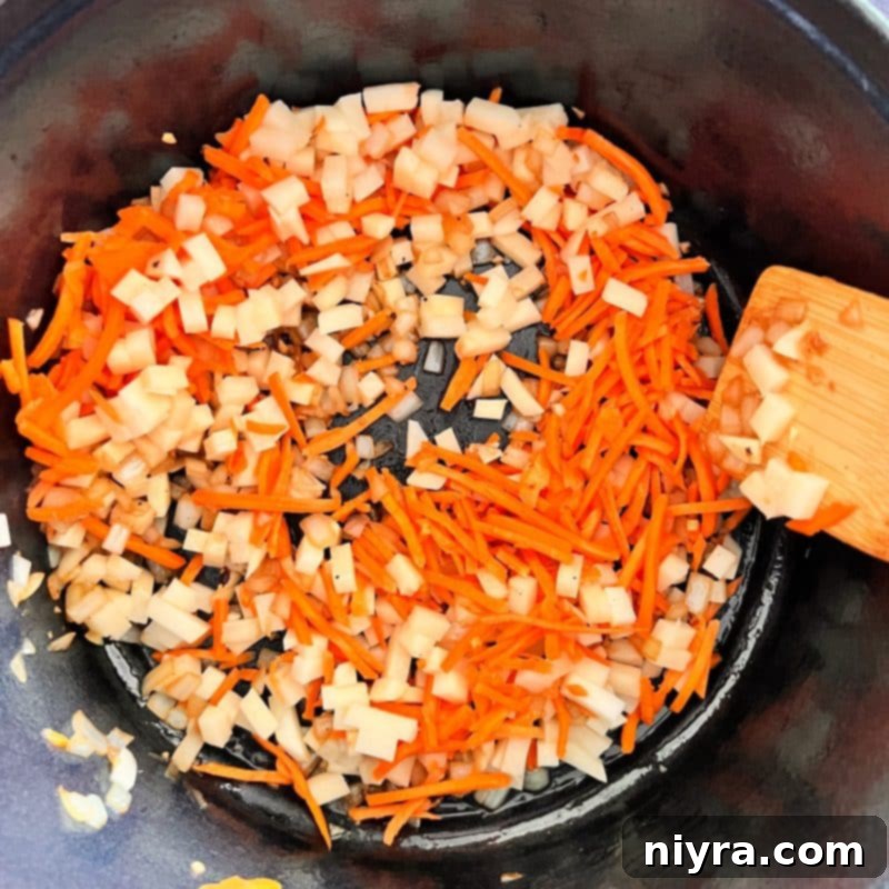 Step 3: Adding carrots and potatoes to the pot for sautéing.