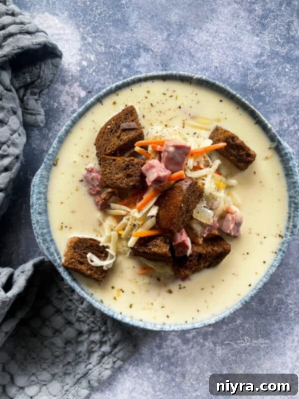 Cream of Reuben Soup in a grey pottery bowl with rye croutons