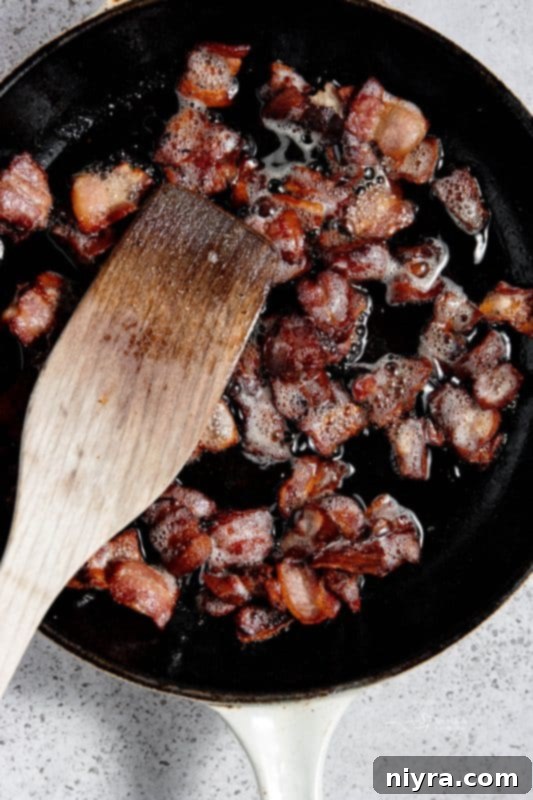 Cooked bacon in a skillet, with remaining bacon fat.