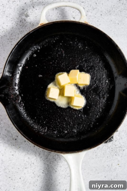 Butter melting in a skillet with bacon grease.