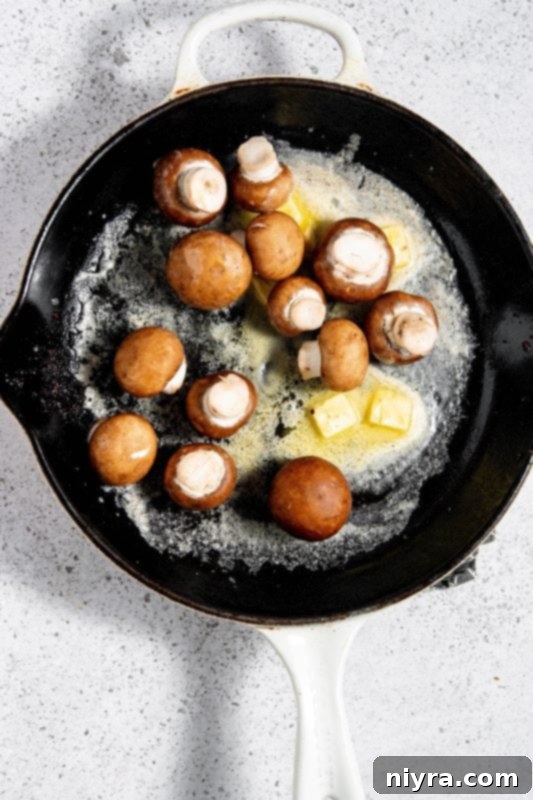 Mushrooms sautéing in a skillet.