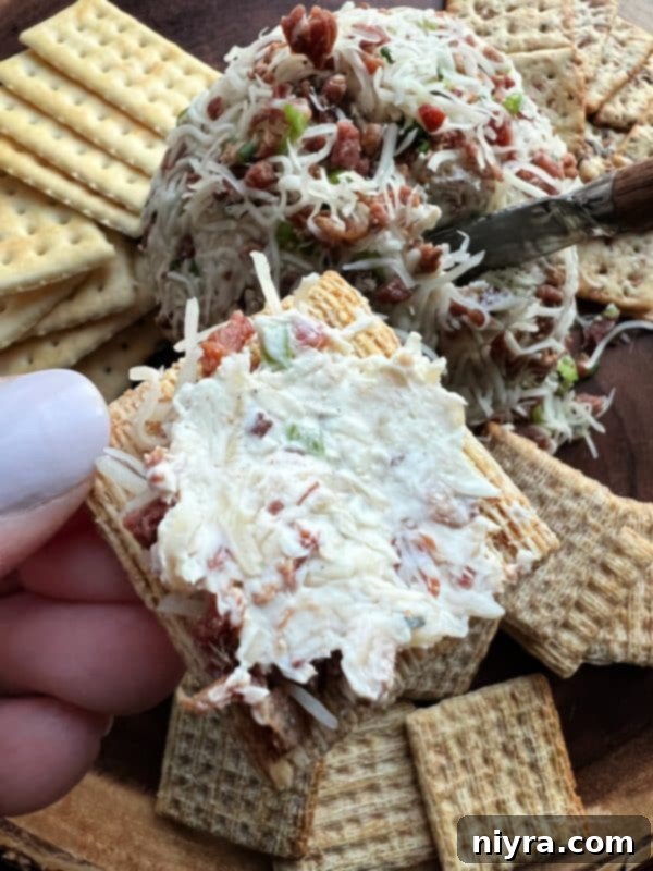 A variety of crackers and vegetables surround the Sauerkraut Bacon & Swiss Cheese Ball