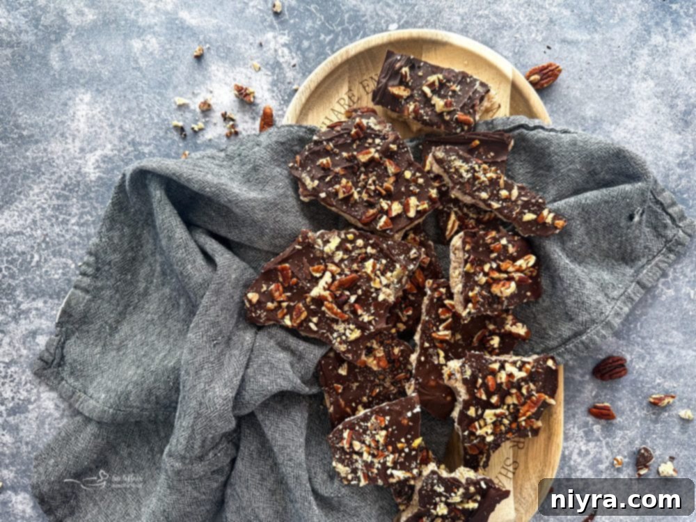 Chocolate-covered toffee with nuts cooling on a baking sheet