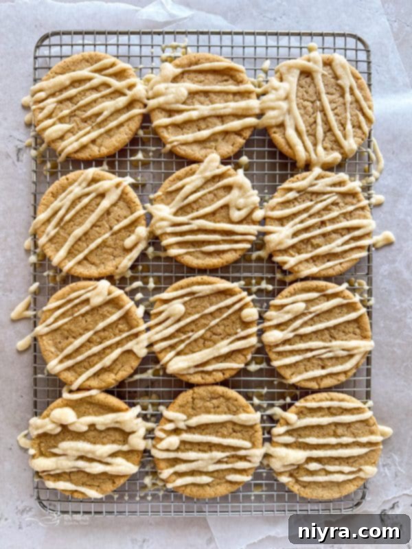 Golden Maple Delights 12 Hands drizzling maple icing over a batch of cooled maple sugar cookies.