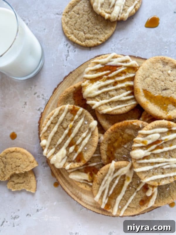 Golden Maple Delights 3 A stack of Iced Maple Sugar Cookies on a white plate, garnished with a maple leaf, highlighting their inviting appeal.