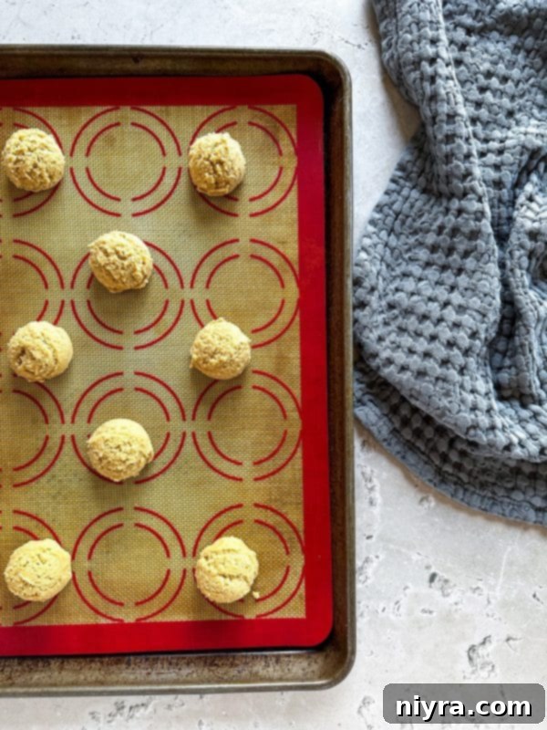 Golden Maple Delights 9 Unbaked maple sugar cookie dough balls neatly arranged on a baking sheet.