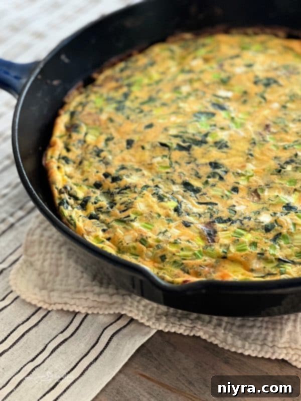 A slice of Bacon and Potato Frittata on a white plate with a fork.